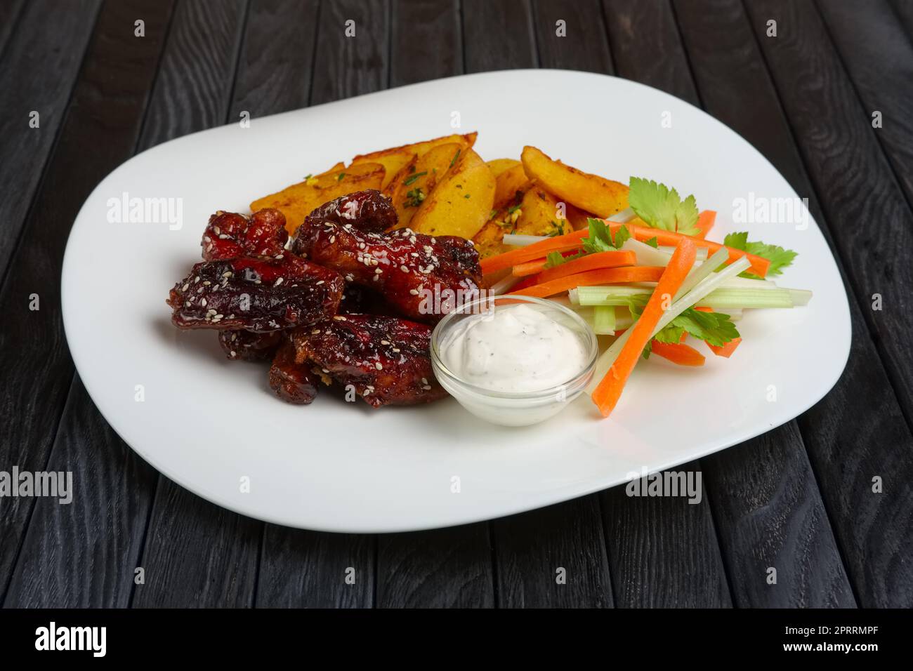 Buffalo Chicken Wings mit gebratenen Kartoffeln und Karotten und Sellerie sticks Stockfoto