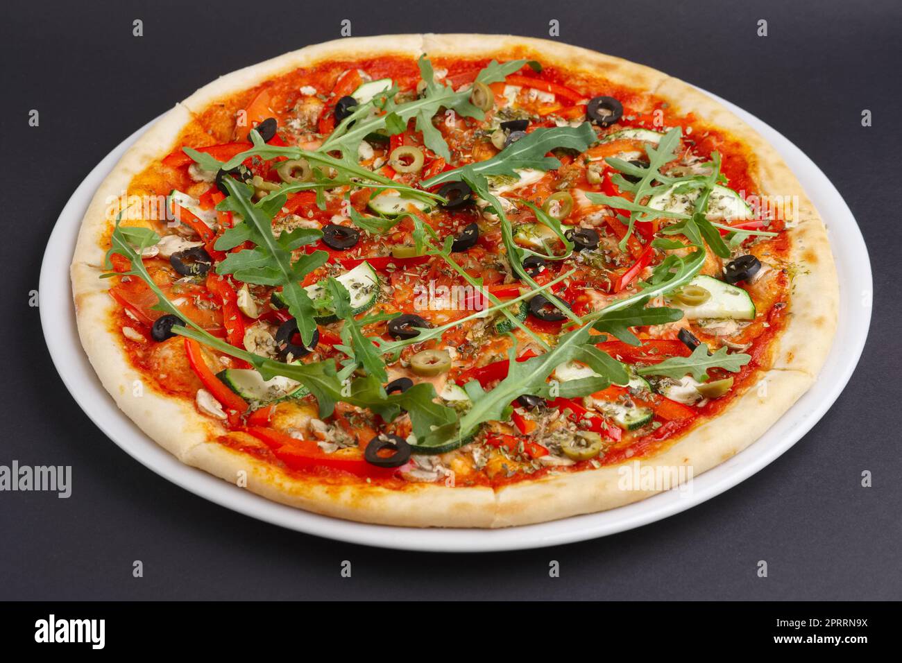 Schlanke Pizza Margherita mit Käse, Rucola, Tomatensauce auf einem weißen Teller. Stockfoto