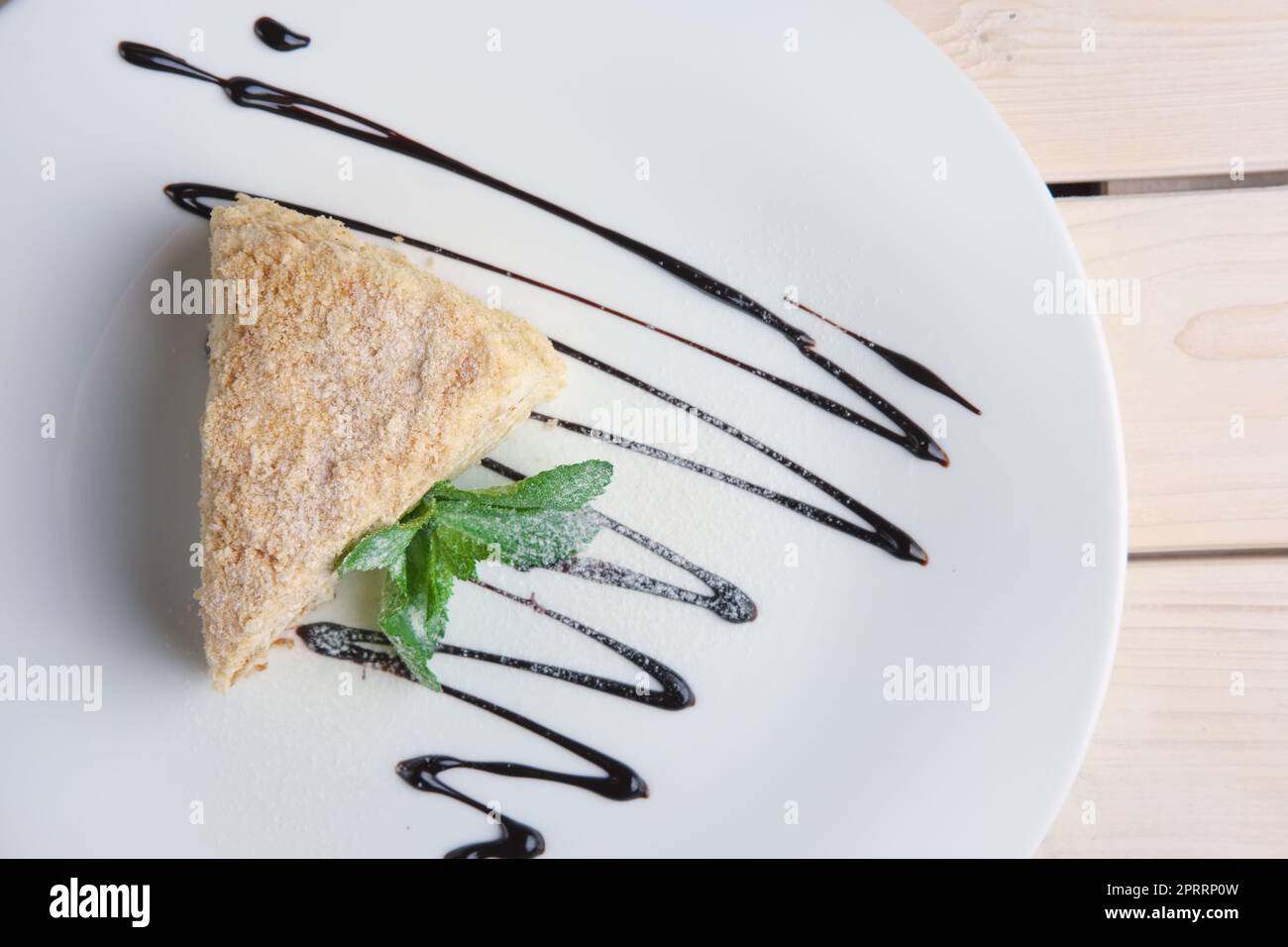 Draufsicht auf napoleon Kuchen auf Teller mit Schokoladensoße. Blätterkuchen mit Pudding Stockfoto