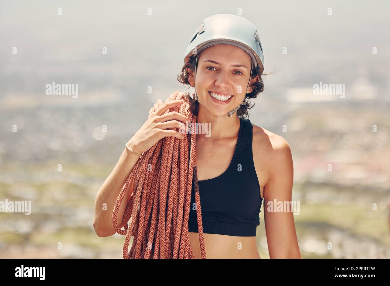 Sportlerin, Helm und Seile für Berg- oder Felsklettern und Wanderabenteuer im Freien. Sport, Fitness und Extremkletterer mit einem Lächeln, Adrenalin und Motivation für Extremsport Stockfoto