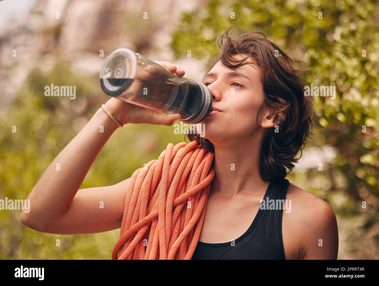 Wasserflasche, Wandern und Sport mit Frau, die Durst hat und während des Fitnesstrainings oder Klettern in der Natur ausreichend Flüssigkeit erhält. Gesundheit, Wellness und Elektrolyt mit Sportlerin auf Abenteuer Stockfoto