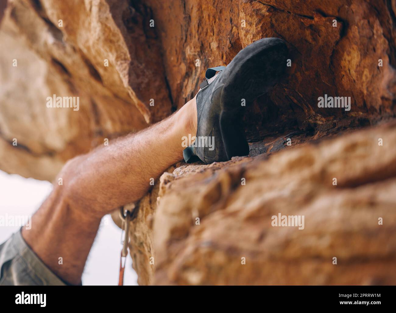 Ein Bein des Mannes klettert auf Felsen, Berge oder Steine für Workout, Abenteuer oder Sport. Felsbrocken, Sport und Fitness des männlichen Klettertrainings im Freien, auf dem Land oder in der Natur Bergsteigen, Wandern oder Klettern. Stockfoto