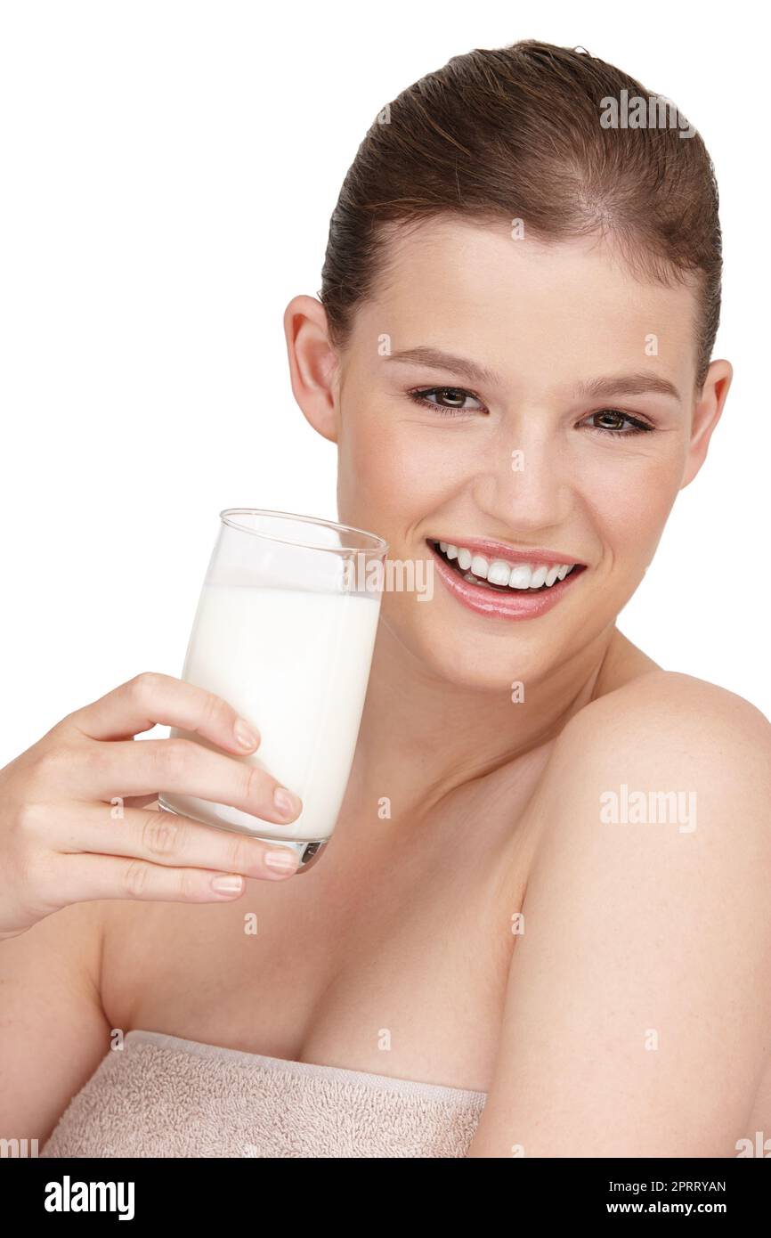 Milch für starke und gesunde Knochen. Ein lächelndes Teenager-Mädchen, das ein Glas Milch in der Hand hält. Stockfoto