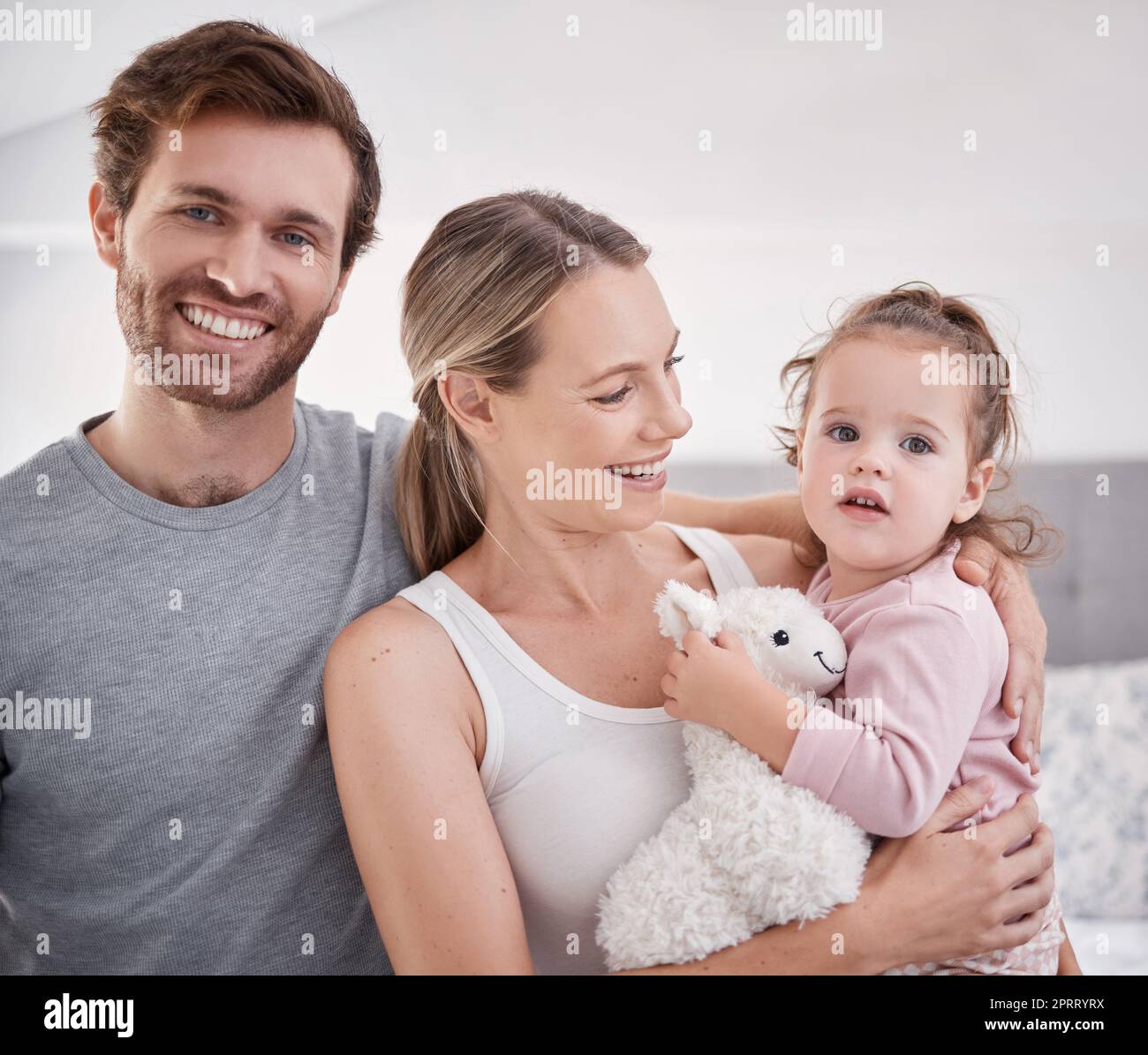 Glückliches Porträt und Familie im Schlafzimmer mit Kind in liebevollem Zuhause mit jungen und fürsorglichen Eltern. Liebe, Fürsorge und Vertrauen von verheirateten Menschen mit einem süßen Mädchen, das zusammen in der Familie lebt. Stockfoto