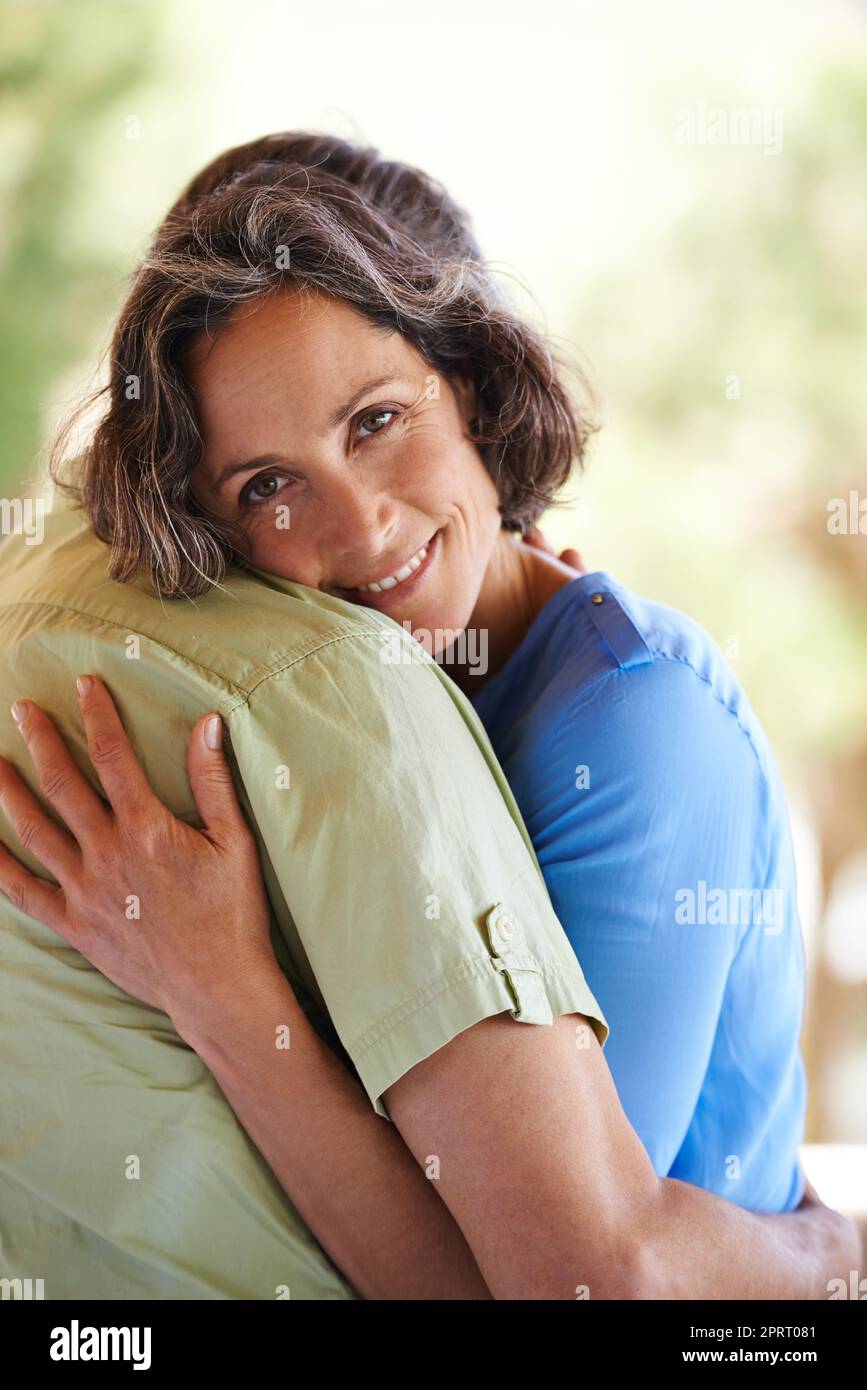 Verliebt in meinen besten Freund. Ein beschnittenes Porträt einer glücklichen Frau, die ihren Mann liebevoll im Freien umarmt. Stockfoto