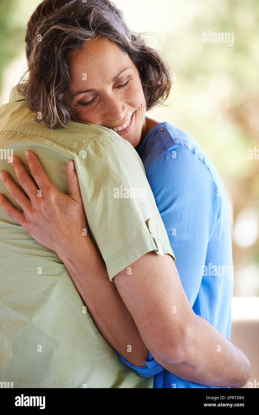 Ich habe dich so sehr vermisst. Eine kurze Aufnahme einer glücklichen Frau, die ihren Mann liebevoll im Freien umarmt. Stockfoto