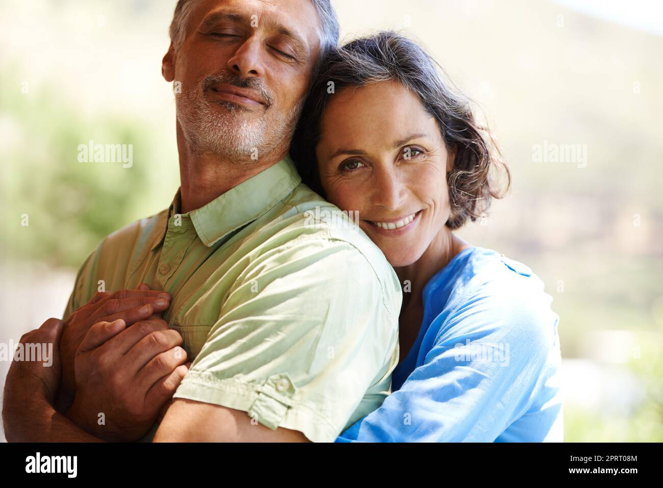 Was würde ich ohne ihn tun? Ein beschnittenes Porträt einer glücklichen Frau, die ihren Mann liebevoll im Freien umarmt. Stockfoto
