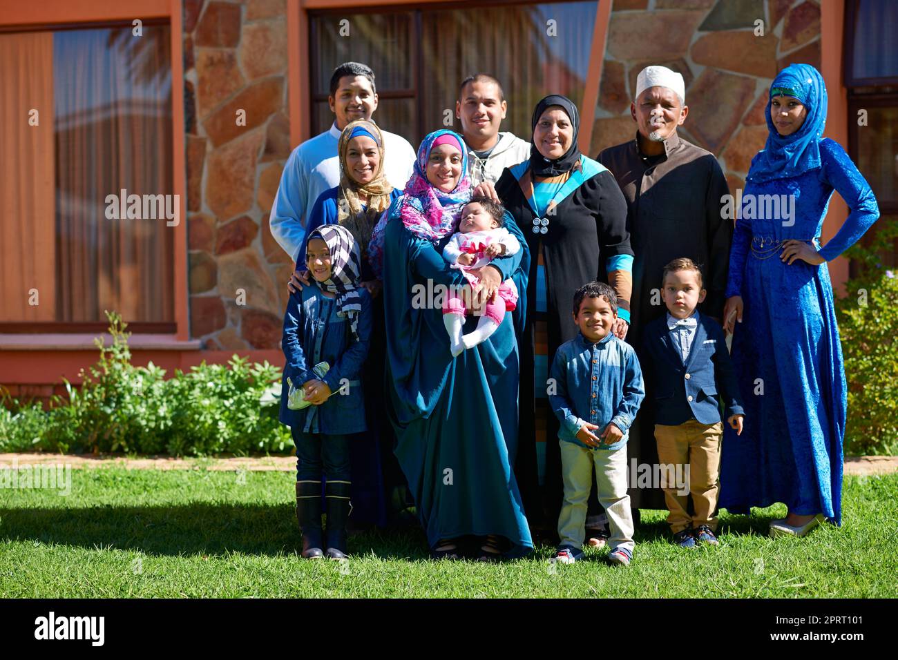 Familie zuerst. Porträt einer glücklichen muslimischen Familie, die vor ihrem Haus zusammensteht. Stockfoto