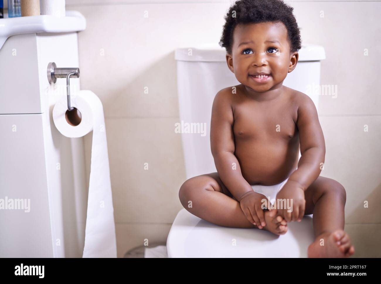 Ich bin bereit für meine erste Töpfchen-Trainingsstunde. Ein entzückender Junge sitzt auf der Toilette im Badezimmer. Stockfoto