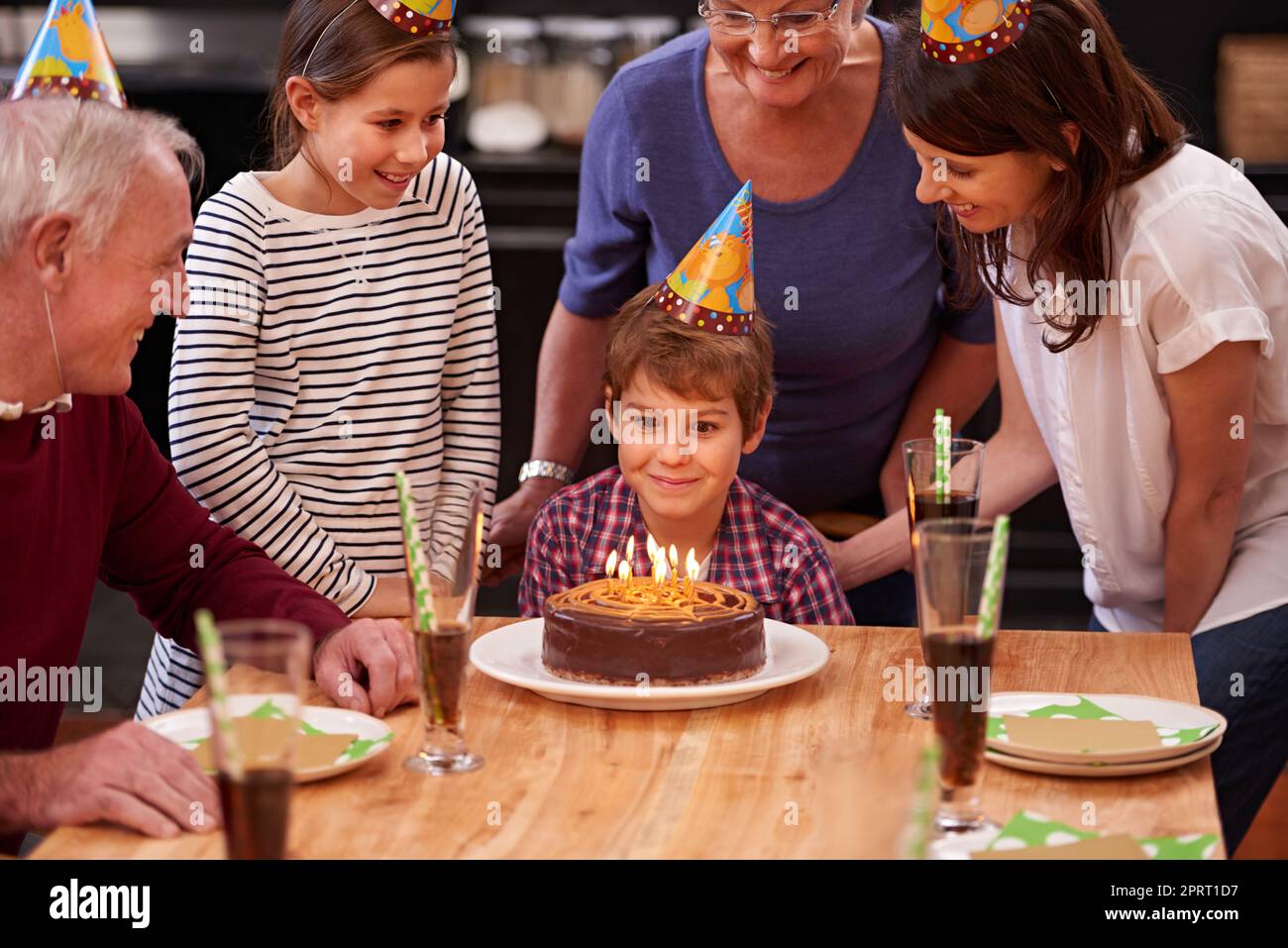 Geburtstage sind eine Art und Weise, uns zu sagen, mehr Kuchen zu essen. Ein glücklicher kleiner Junge feiert seinen Geburtstag mit seiner Familie. Stockfoto