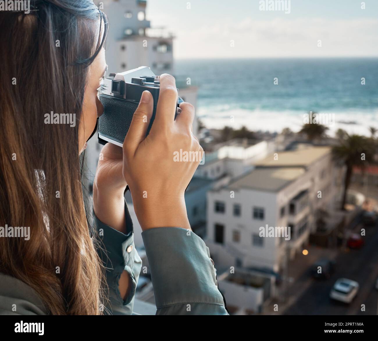 Reisen, Aussicht und Frau mit Kamera im Hotel, die im Urlaub Fotos von der Stadt, Gebäuden oder dem Meer macht. Fotografin, Mädchen auf dem Balkon, die Fotos für glückliche Erinnerungen, Erinnerungen oder Momente macht. Stockfoto