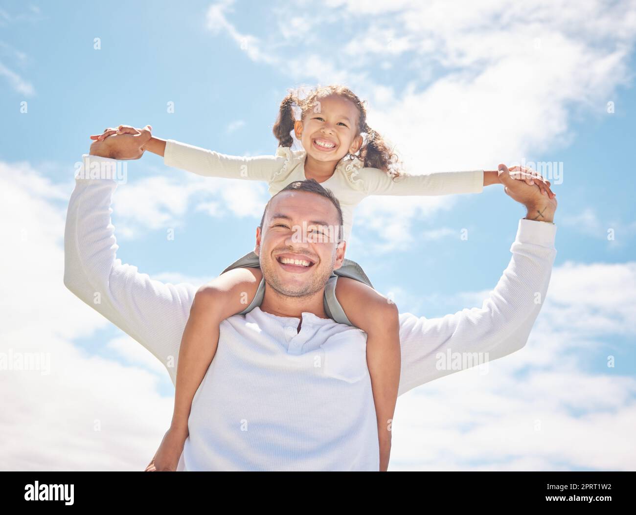 Familie, Mädchen und Vater im Urlaub mit Wolken, blauem Himmel, Sonne und Sommer. Glücklich, fürsorglich und lieb und Dad spielt mit Jugendkindern Porträt in der Ferienzeit, genießt, hat Spaß und Huckepack Stockfoto