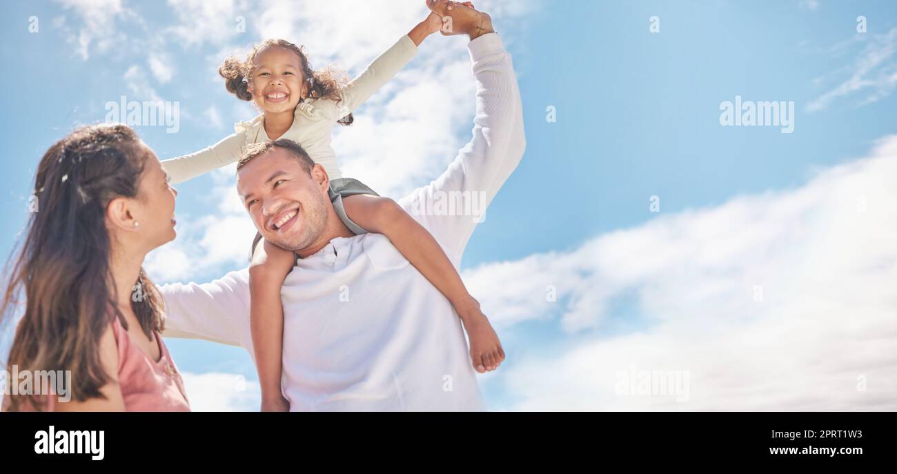Familie, Kinder und Liebe mit Pflegeeltern und Adoptivmädchen draußen tagsüber mit blauem Himmel im Hintergrund. Mutter, Vater und Tochter verbringen Zeit miteinander und verbinden sich mit Liebe und Fürsorge Stockfoto