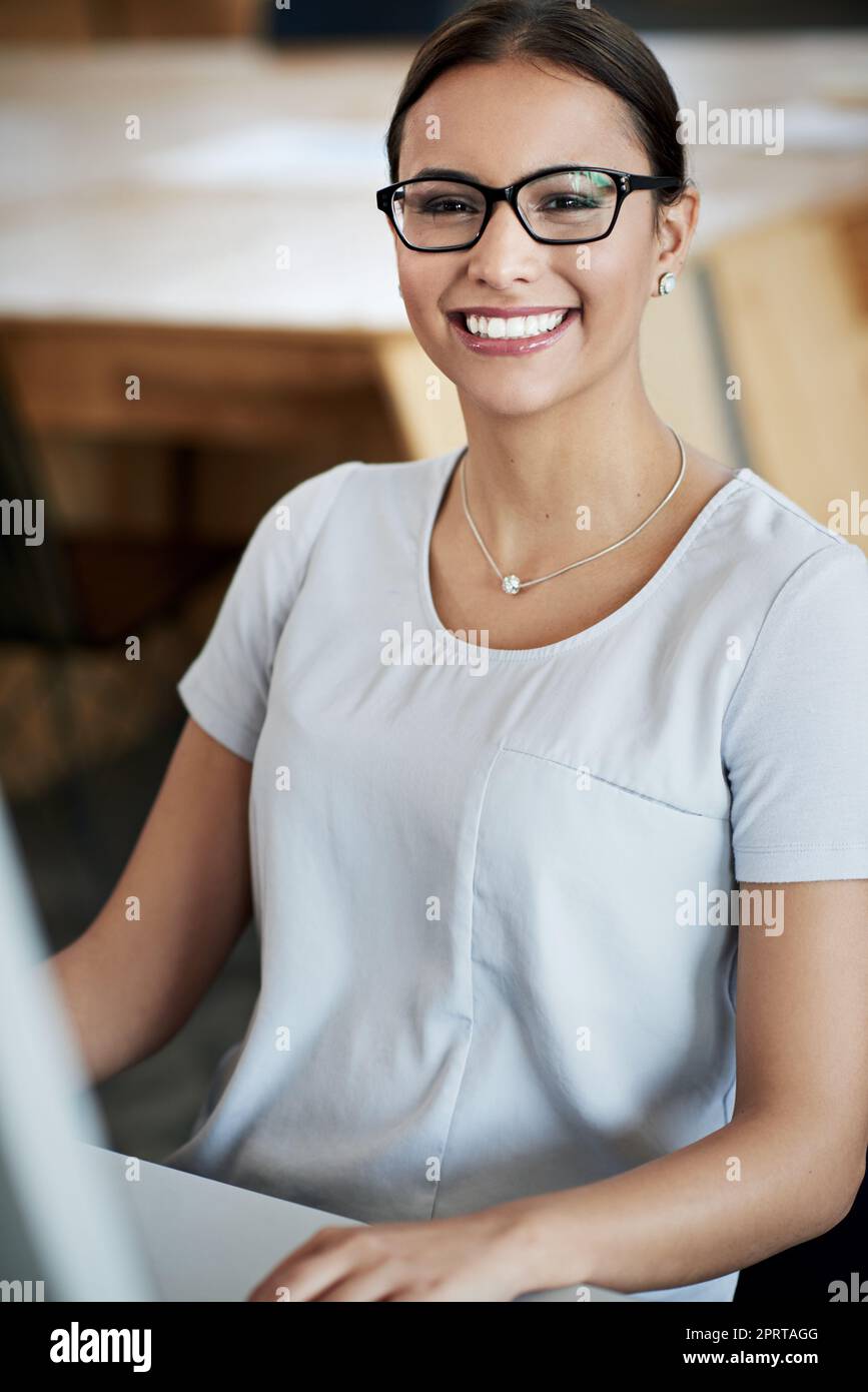 Meine Karrieresträume leben. Porträt einer attraktiven jungen Frau, die in einem Büro sitzt. Stockfoto