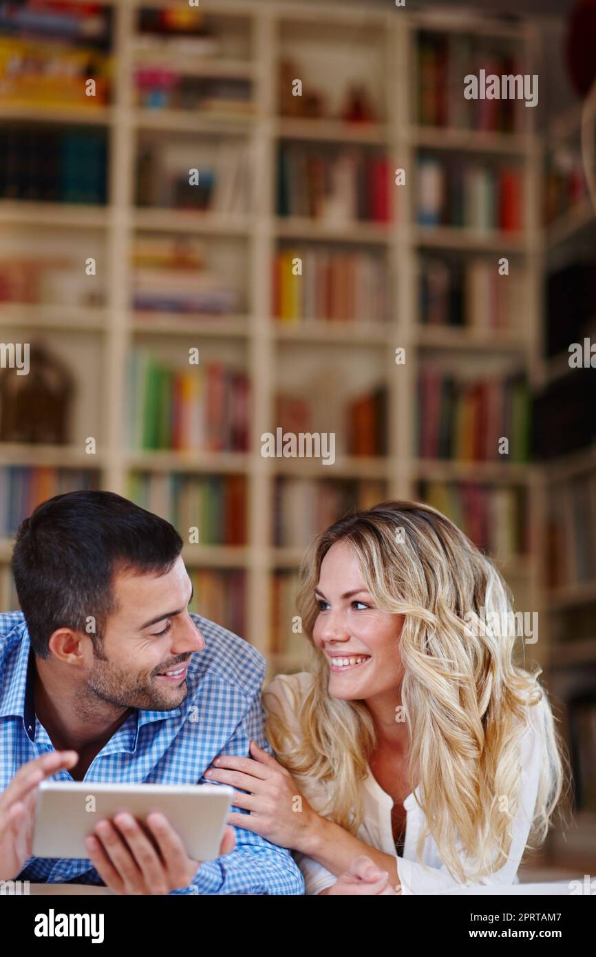 Planung ihres nächsten romantischen Kurzurlaubs. Ein junges Paar sitzt zu Hause mit einem digitalen Tablet. Stockfoto