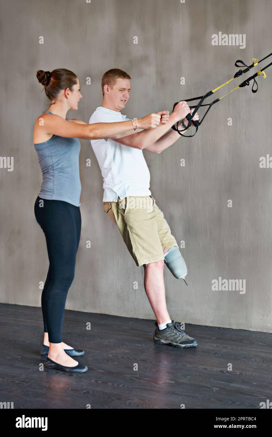 Eine weibliche Physiotherapeutin, die eine Sitzung mit einem jungen männlichen Amputierten hat. Stockfoto