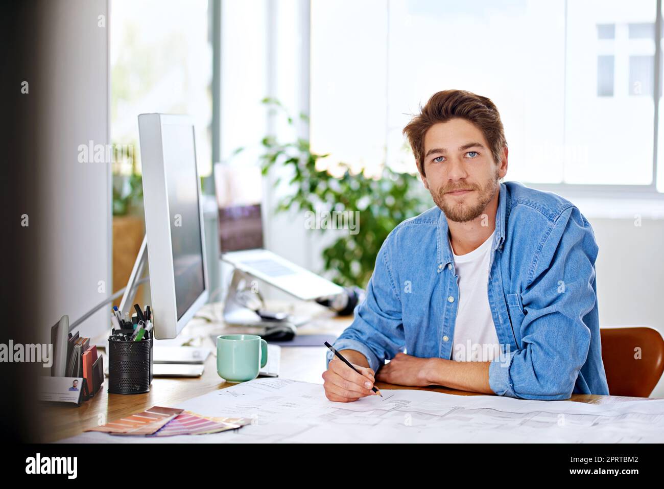Moderne Technologie ist der Schöpfer neuer Jobs. Ein hübscher junger Designer in seinem Büro. Stockfoto