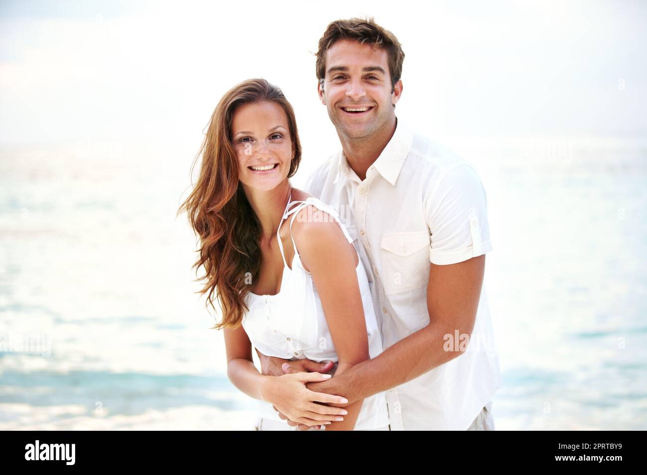 Entspannt und verliebt. Porträt eines wunderschönen jungen Paares, das sich liebevoll am Strand hält. Stockfoto