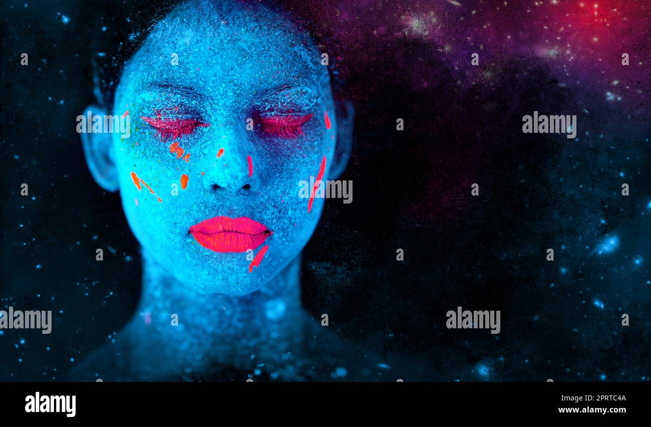 Schönheit aus einer anderen Welt. Eine junge Frau posiert mit Neonfarbe auf ihrem Gesicht. Stockfoto