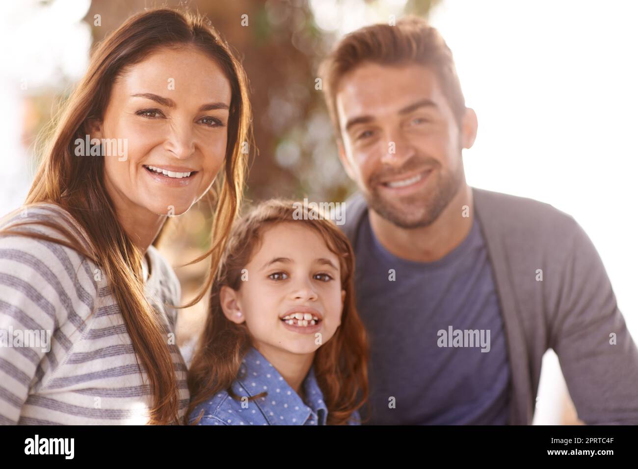 Morgens Zeit für die Familie. Beschnittenes Porträt einer glücklichen Familie, die draußen zusammen sitzt. Stockfoto