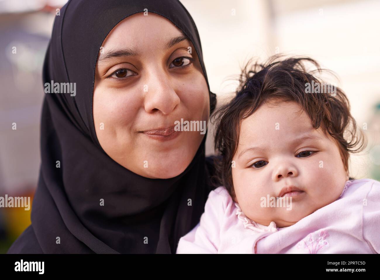 Sie nimmt ihrem Vater nach. Eine muslimische Mutter und ihr kleines Mädchen. Stockfoto
