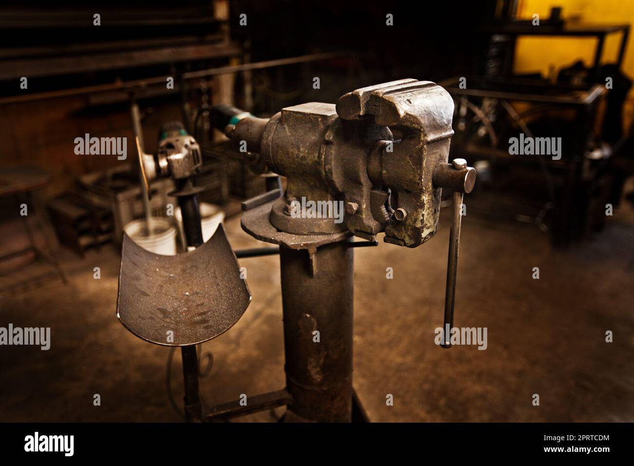 Das Handwerk einer vergangenen Ära. Ein freistehender Schraubstock mitten in einer Eisenarbeiterwerkstatt. Stockfoto