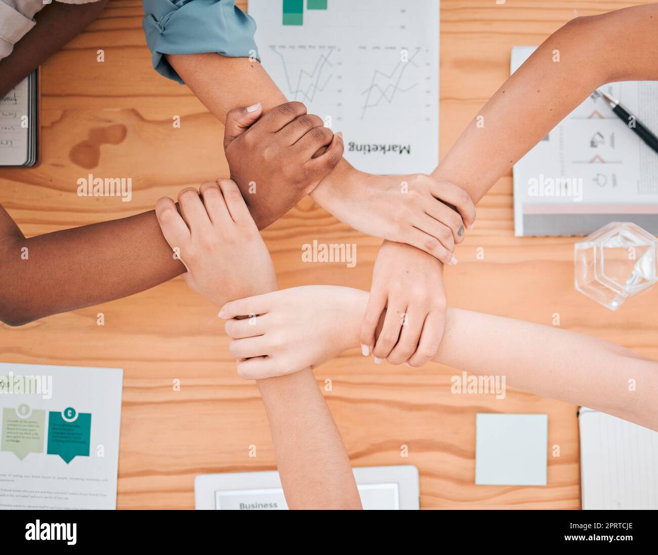 Teambildung, Diversität und Sicht auf die Hände von Geschäftsleuten in Meetings für Strategie, Verbindung und Unterstützung. Teamarbeit, Mission und Zusammenarbeit mit Mitarbeitern, die sich für die Gemeinschaft am Handgelenk halten Stockfoto