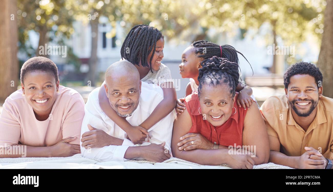 Natur, Garten und Porträt einer glücklichen schwarzen Familie, die sich im Sommerurlaub zusammen entspannen. Lächeln, parken und positive afrikaner bei einem Picknick draußen während eines Urlaubs auf dem Land. Stockfoto