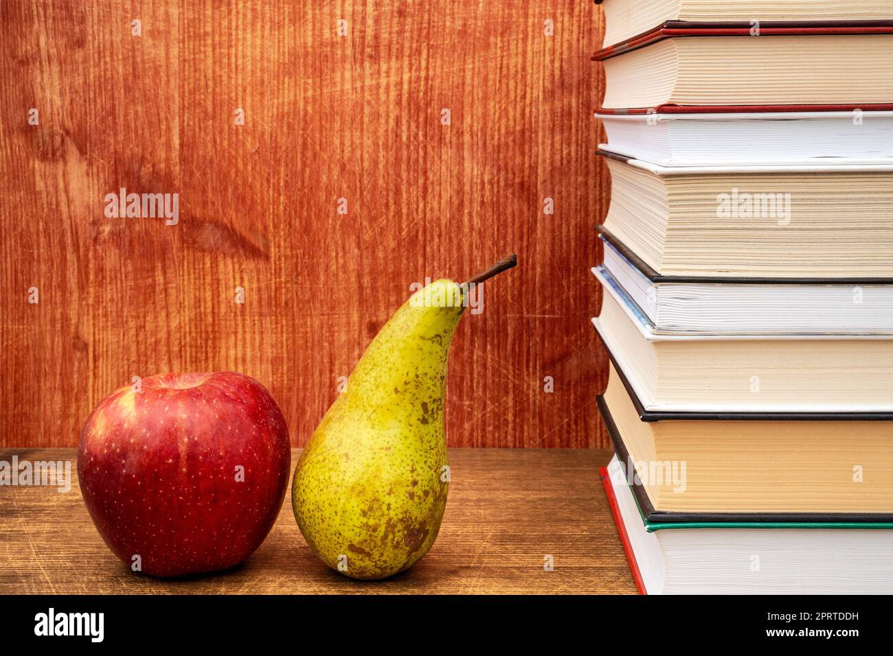 Ein Stapel Bücher, ein Apfel und eine Birne Stockfoto