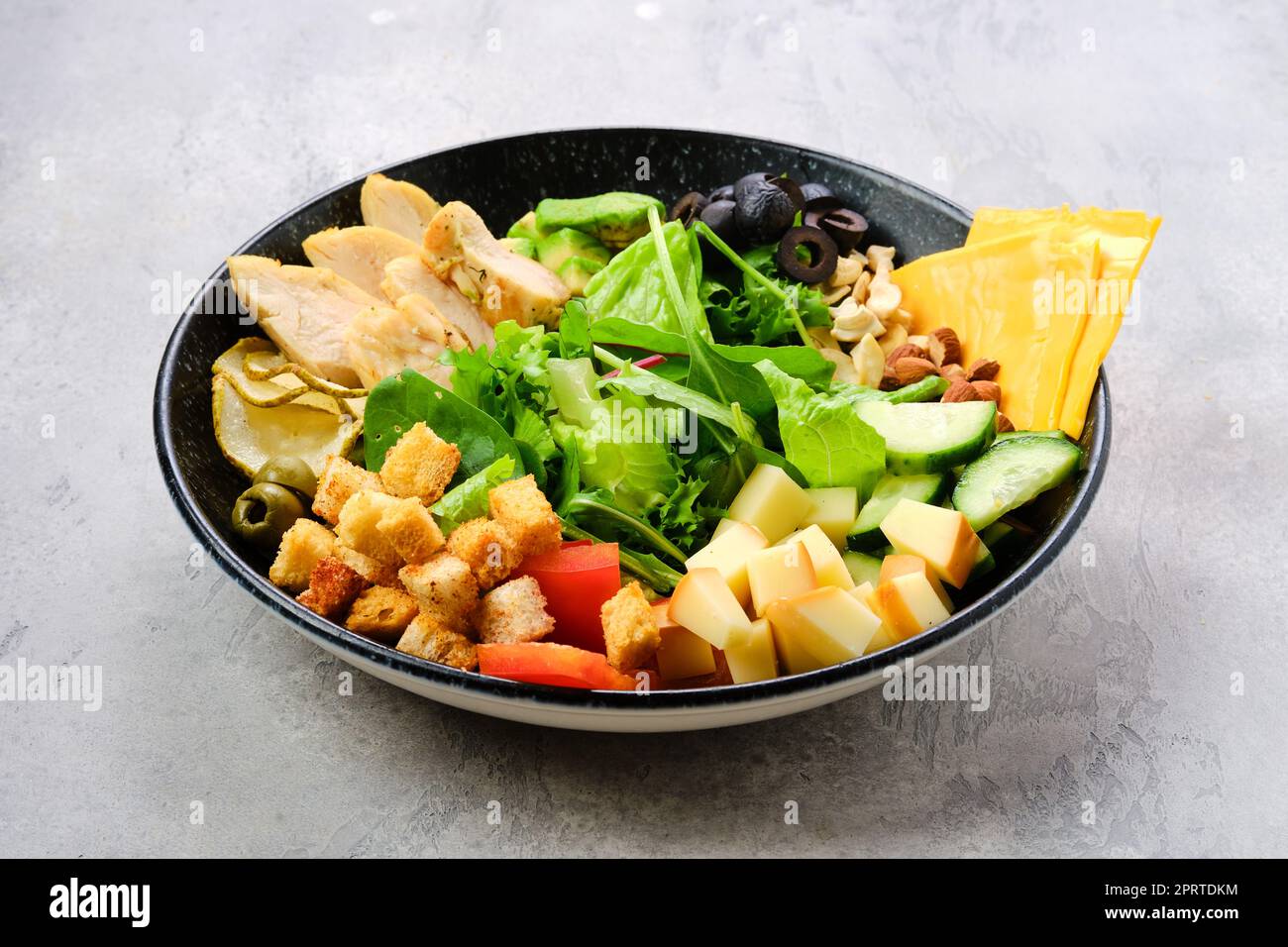 Schüssel mit Salatmischung und verschiedenen Snacks Stockfoto