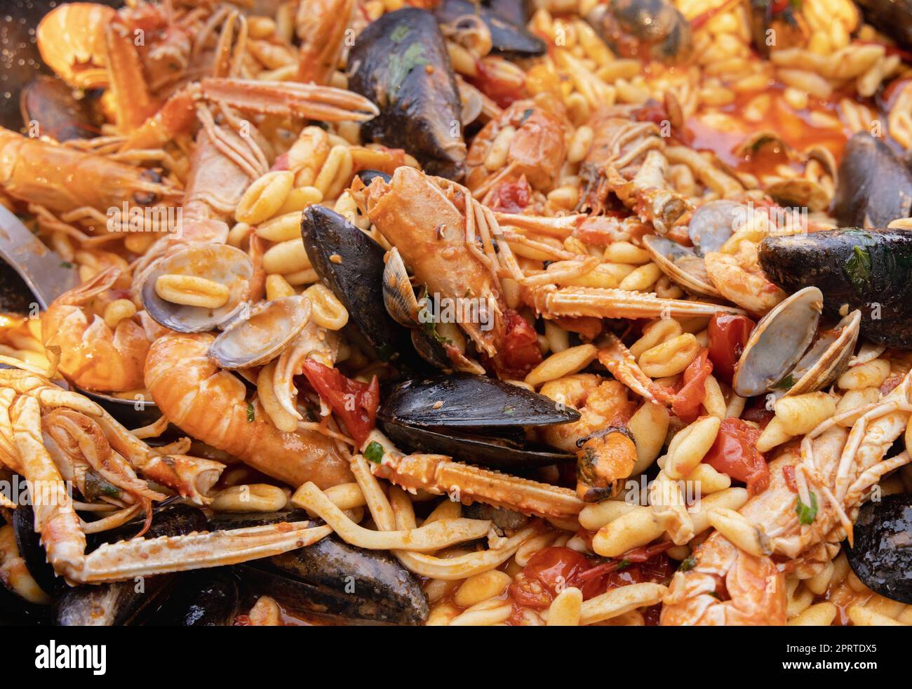 Italienische Cavatelli allo scoglio, Pasta mit Meeresfrüchten und Tomaten in der Pfanne Stockfoto