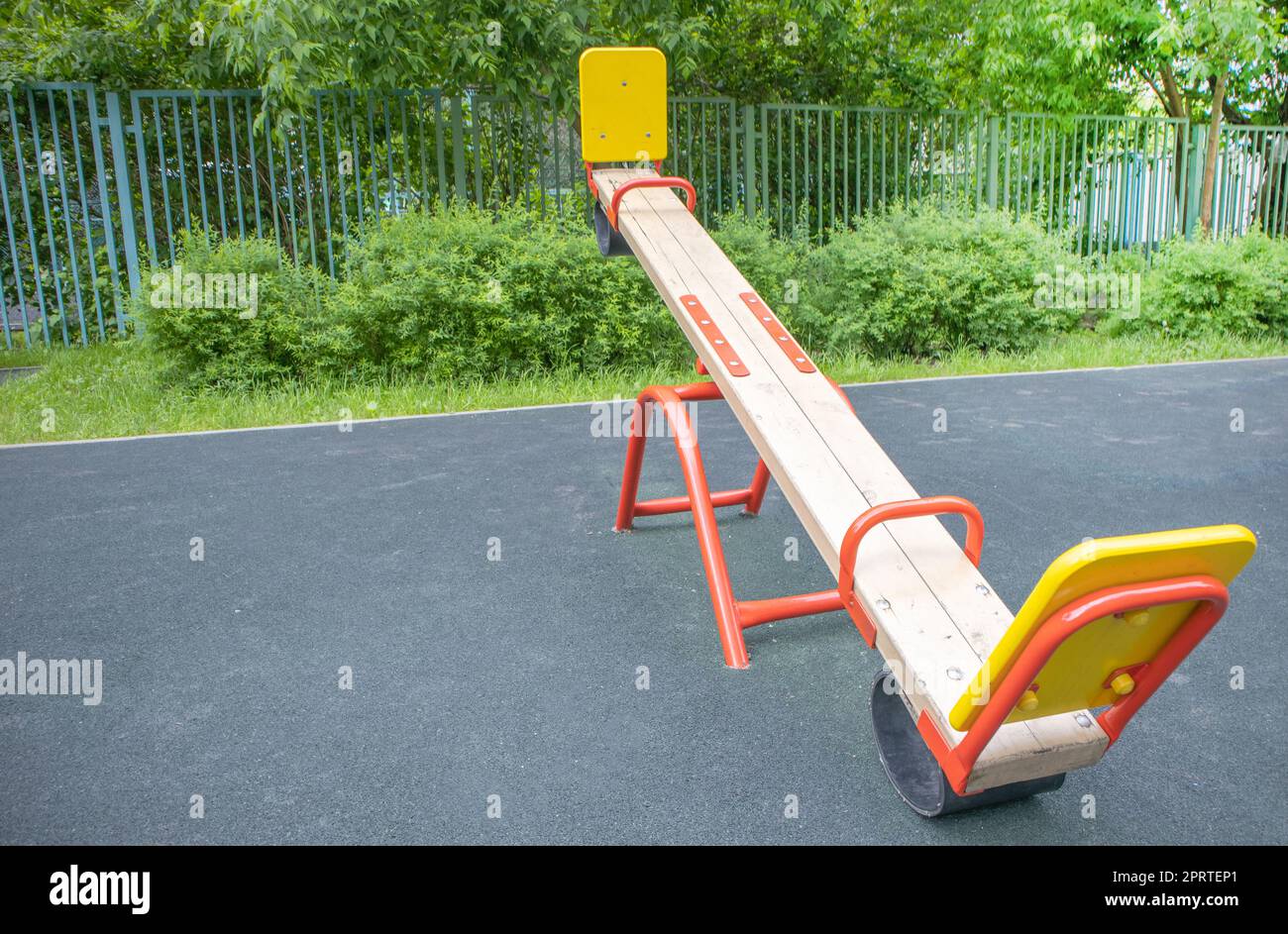 Balancierende Schaukel in Form eines Holzbretts auf einem leeren Spielplatz im Freien, Kinderspielplatz Stockfoto