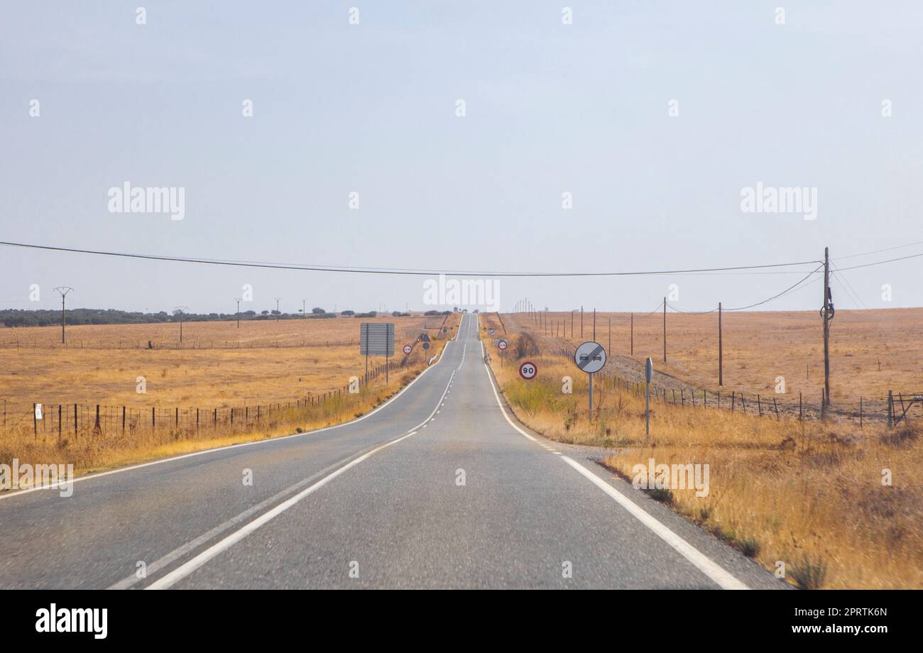 Lokale Straße mit ständigen Änderungen der Steigung. Hügelige Straße, die durch Yelow Weiden führt Stockfoto