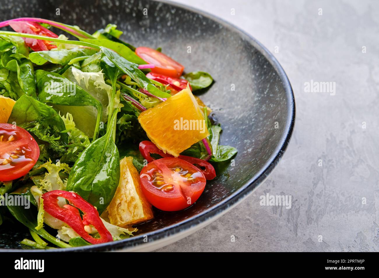 Nahaufnahme von würzigem Salat mit Orange, Chili, Tomaten, Gurke und Avocado Stockfoto