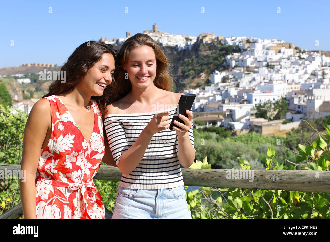 Glückliche Touristen, die in den Sommerferien ihr Smartphone überprüfen Stockfoto
