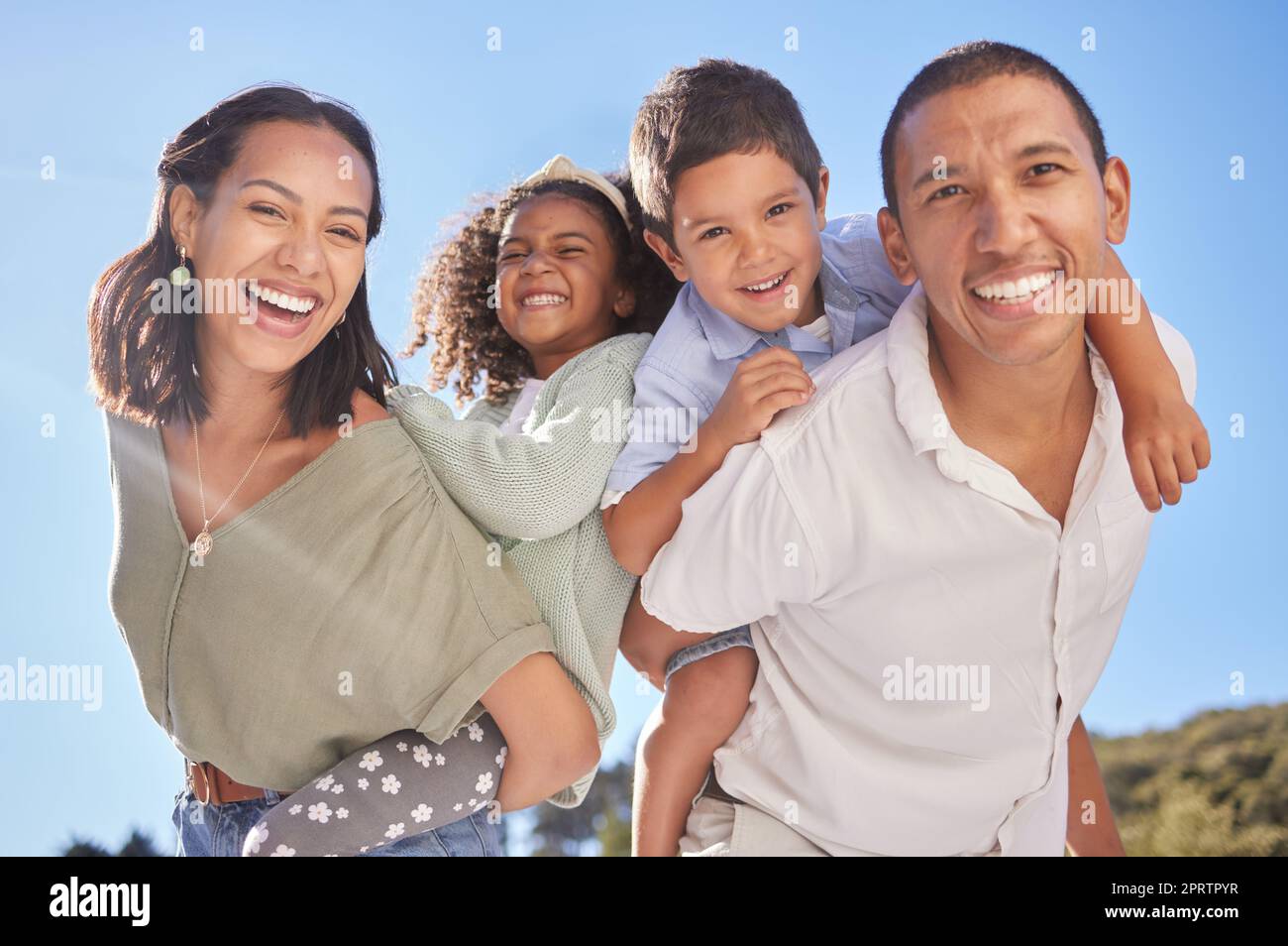 Fröhliches Familienporträt, Eltern nehmen Kinder mit und lächeln zusammen im Park im blauen Himmel mit Vater. Junge Mutter mit süßen Kindern, lustiger Sonnenschein, Glück und wunderschöner Sommerurlaub in brasilien Stockfoto