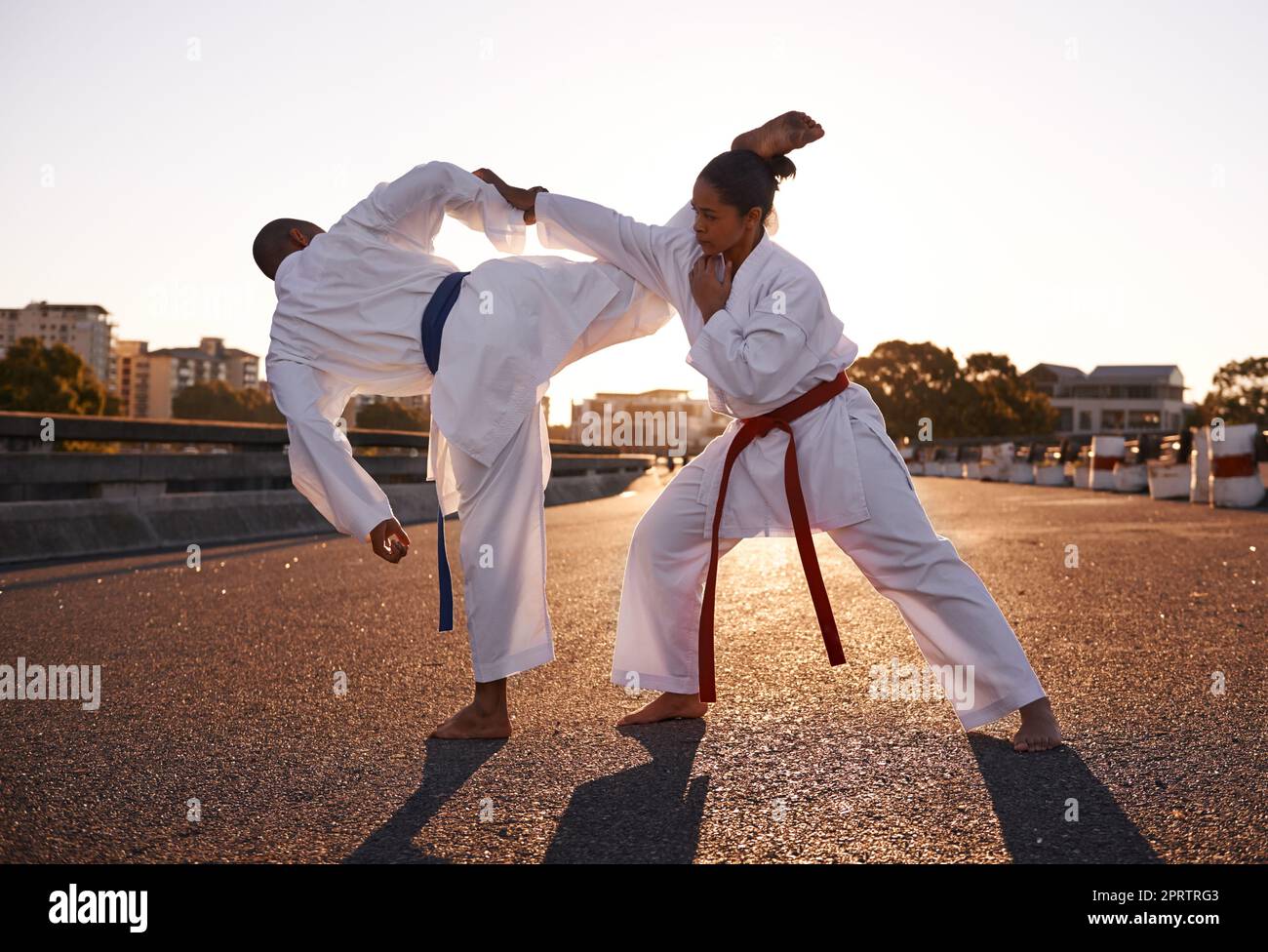 Mit dem Ziel auf ihren Kopf. Zwei Sportler stehen sich gegenüber und üben ihr Karate, während sie GI tragen. Stockfoto