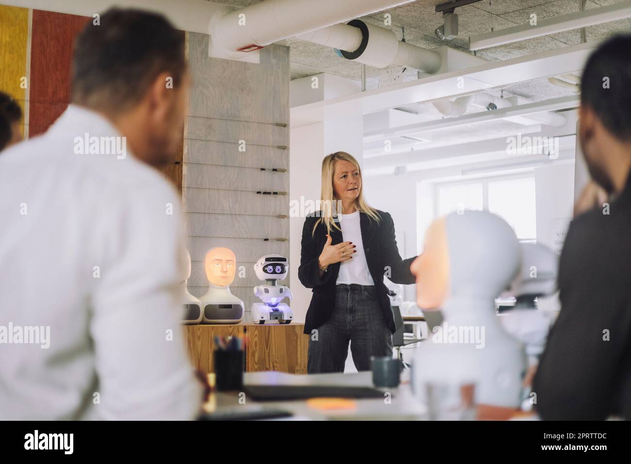 Professorin erklärt Schülerinnen im Innovationslabor über Roboter Stockfoto