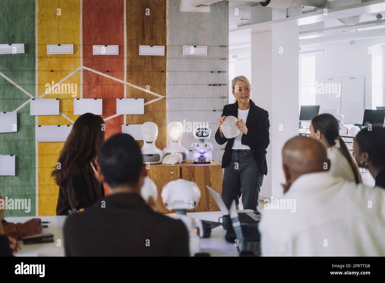 Reife Lehrerin, die multirassische Schüler über Roboter im Innovationslabor erklärt Stockfoto