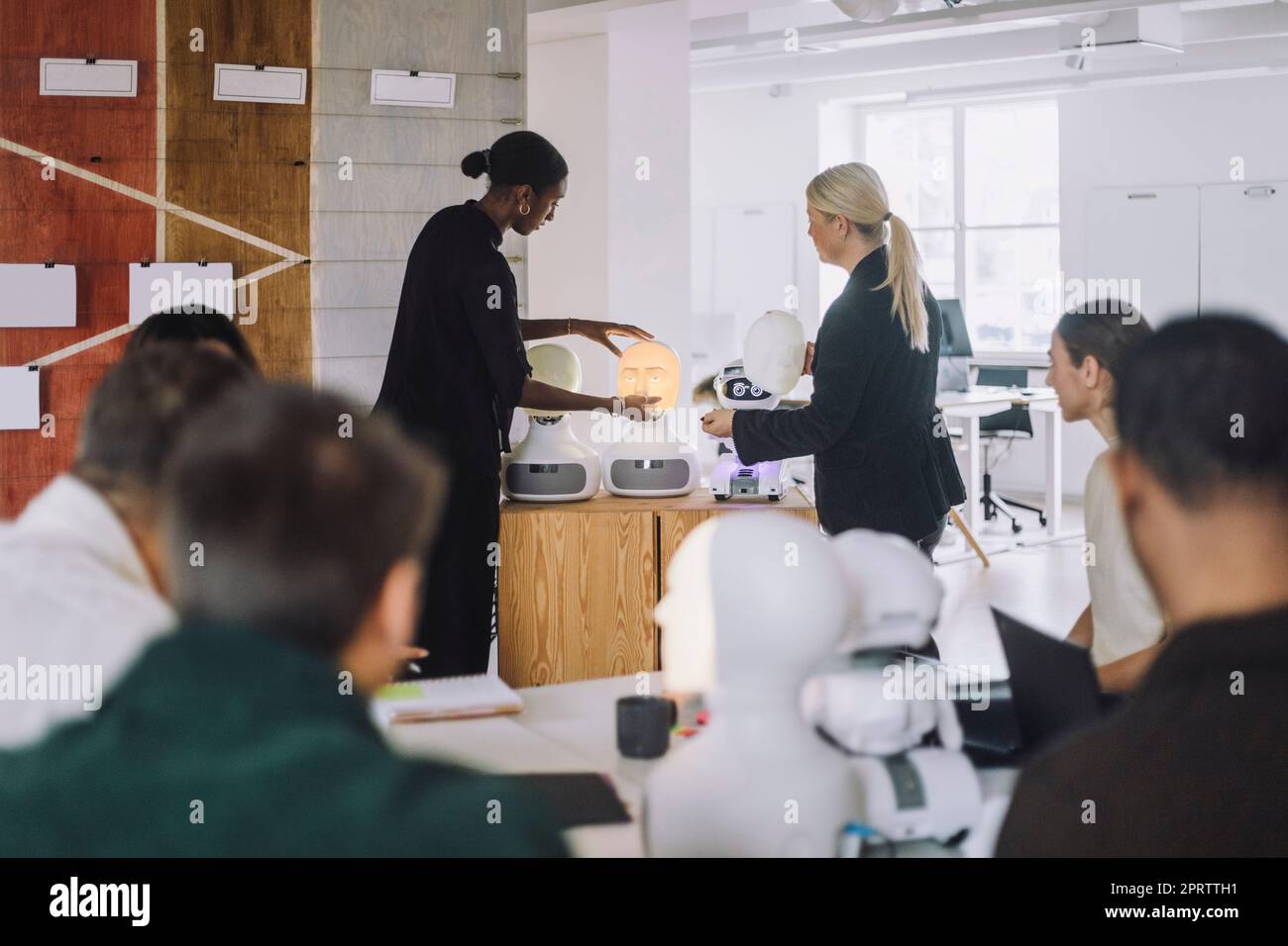 Reife Lehrerin, die Schülerin über den sozialen Roboter im Innovationslabor erklärt Stockfoto