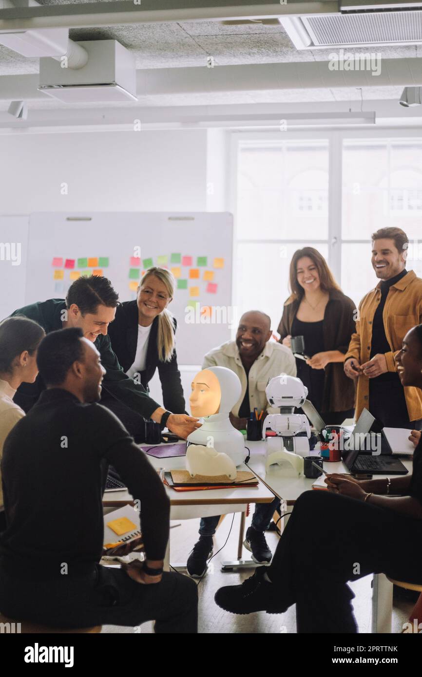 Multiethnische Studenten und Professoren diskutieren über soziale Roboter im Innovationslabor Stockfoto