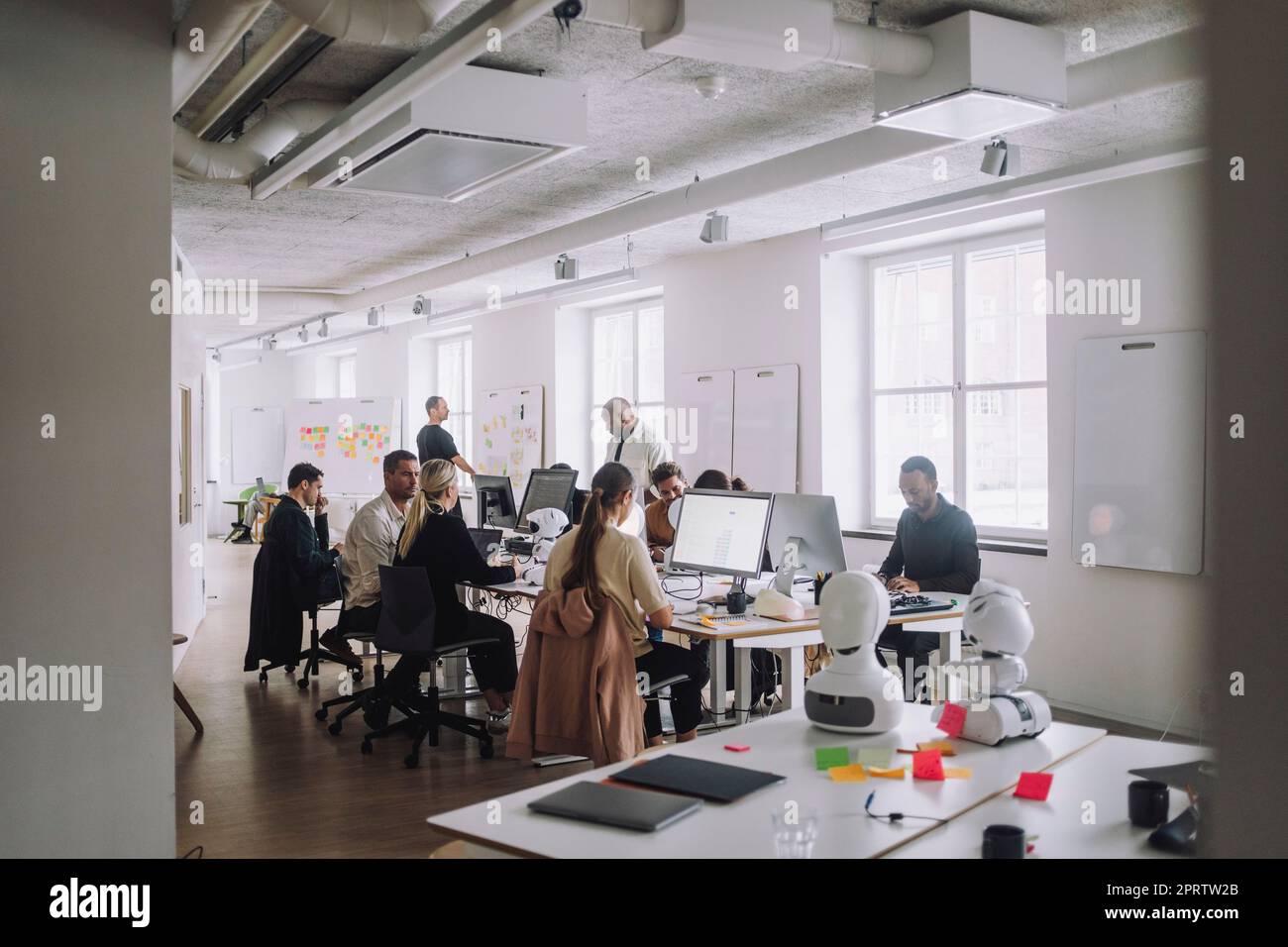 Multirassenprofessoren und Doktoranden diskutieren über Computer am Schreibtisch im Innovationslabor Stockfoto