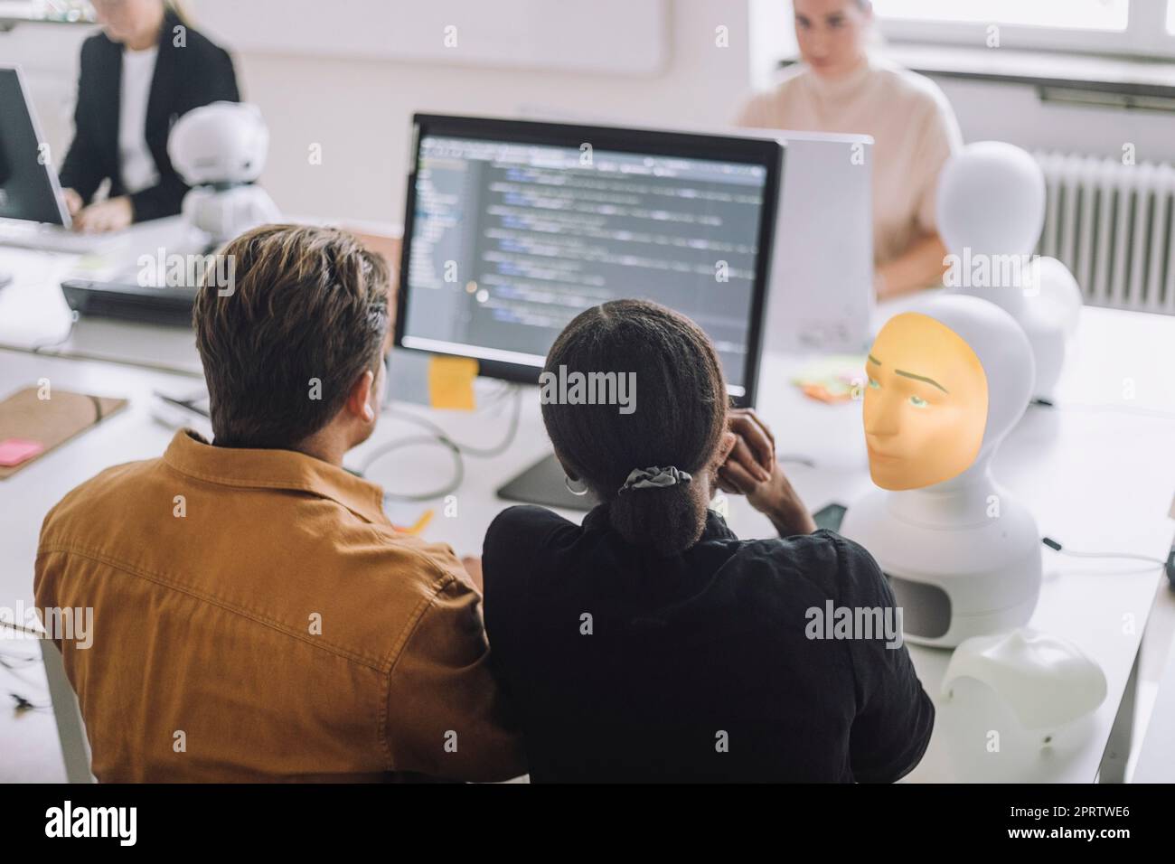 Rückansicht multiethnischer Schüler und Studenten, die über Computer im Innovationslabor diskutieren Stockfoto