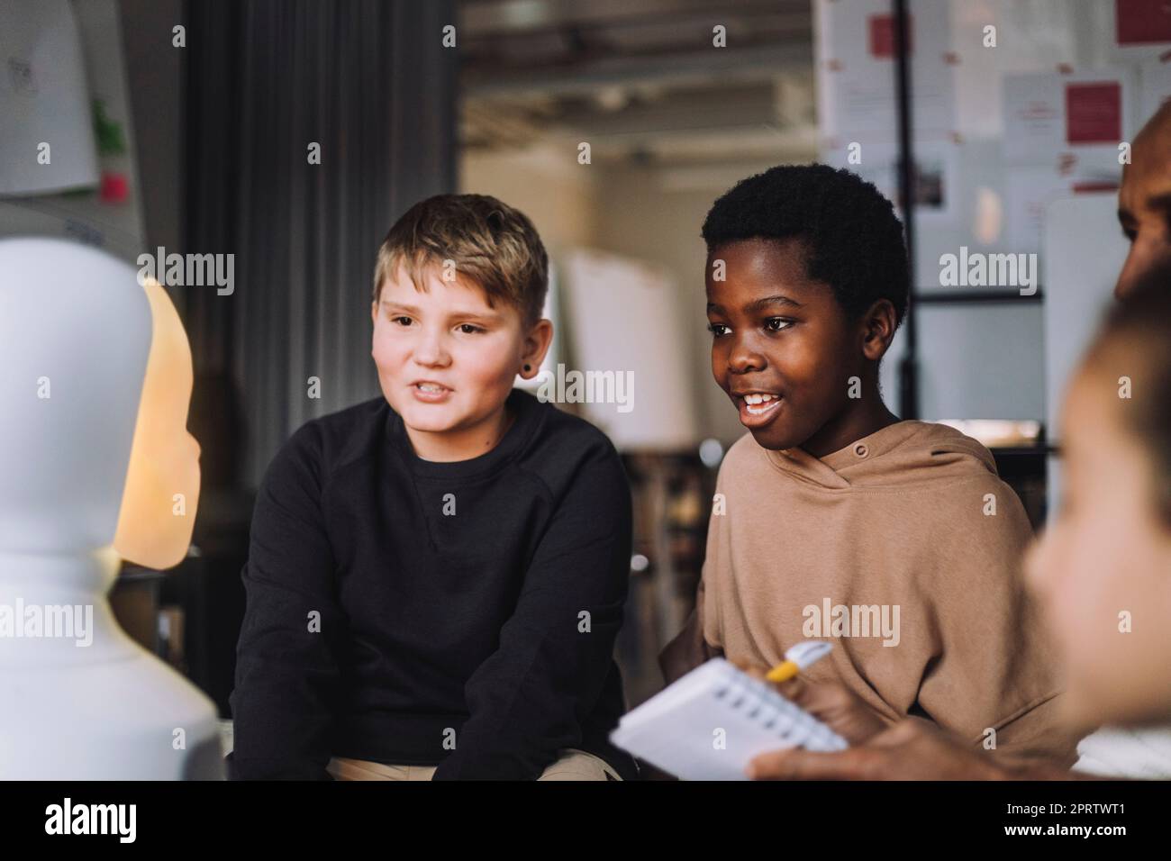 Neugierige Studenten sehen sich den sozialen Roboter im Innovationslabor an Stockfoto