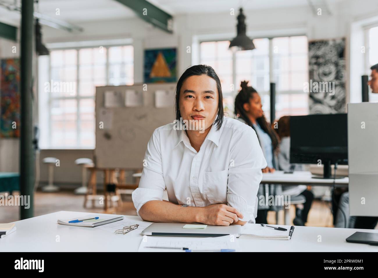 Porträt eines Geschäftsmannes am Schreibtisch in einem modernen Büro Stockfoto