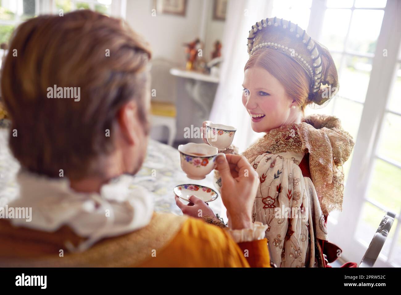 Das königliche Leben leben. Ein König und eine Königin, die zu Hause gemeinsam Tee trinken. Stockfoto