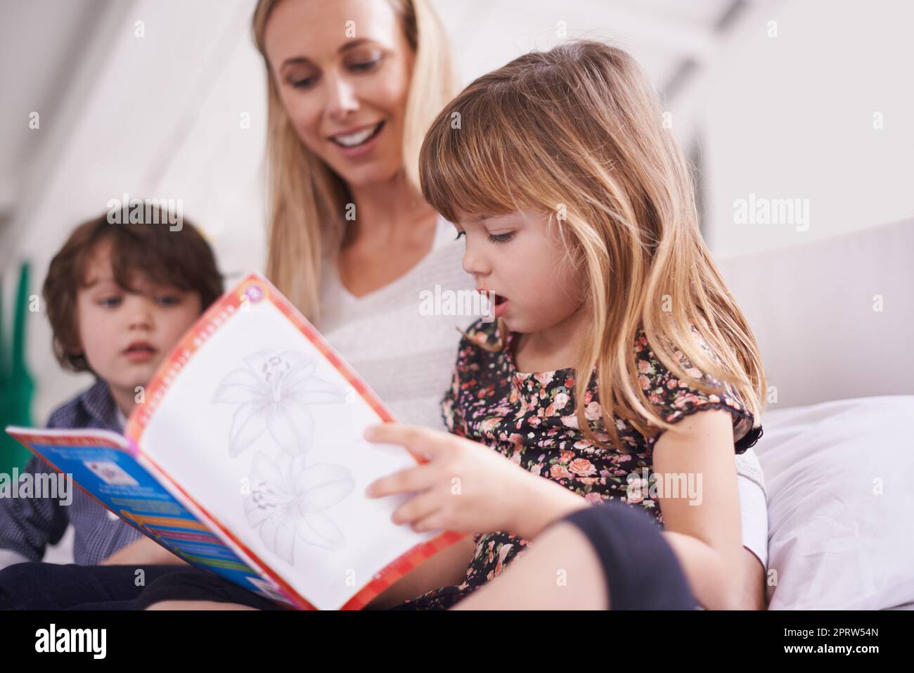 Eine Mutter, die mit ihren Kindern zu Hause liest. Stockfoto