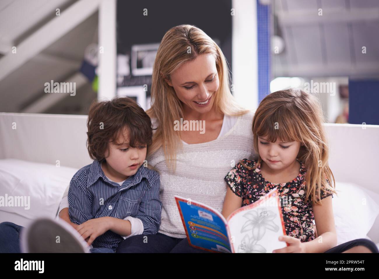 Lesezeit mit Mama. Eine Mutter, die mit ihren Kindern zu Hause liest. Stockfoto