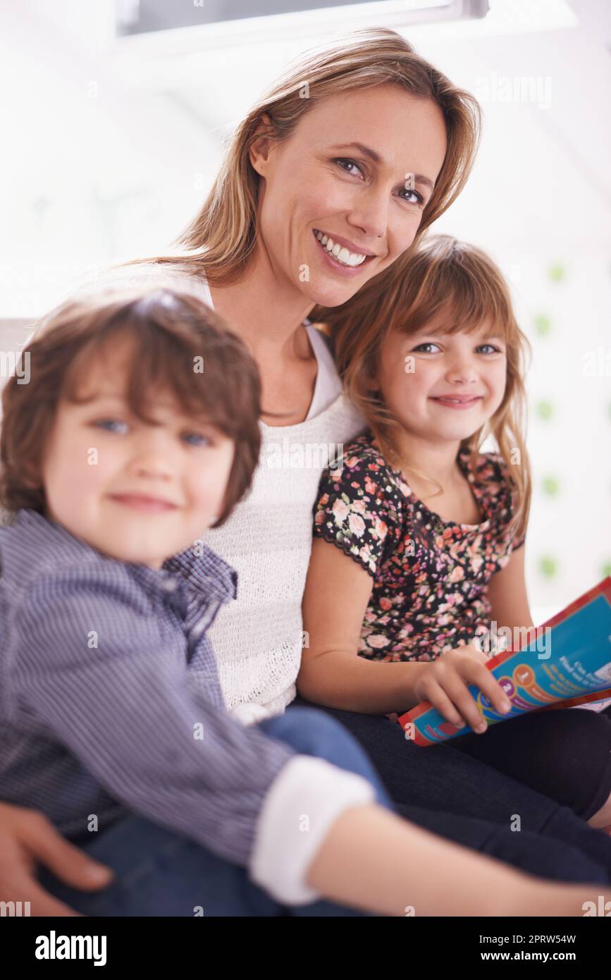 Wir lieben die Geschichte itme. Eine Mutter, die mit ihren Kindern zu Hause liest. Stockfoto