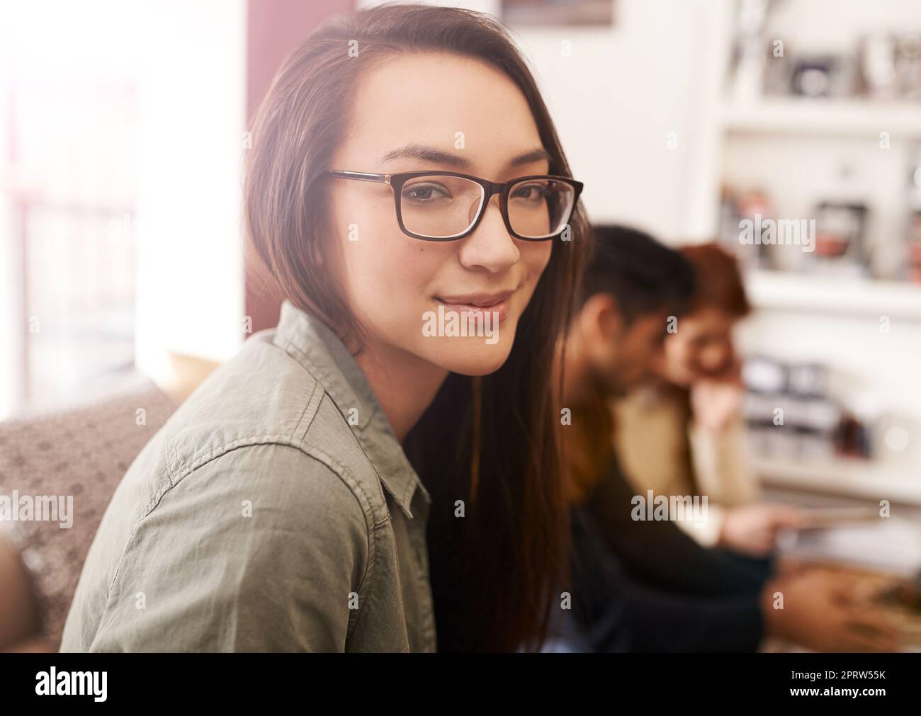 Wir alle brauchen eine Auszeit. Porträt einer jungen Frau in einem Café mit ihren Freunden, die im Hintergrund sitzen. Stockfoto